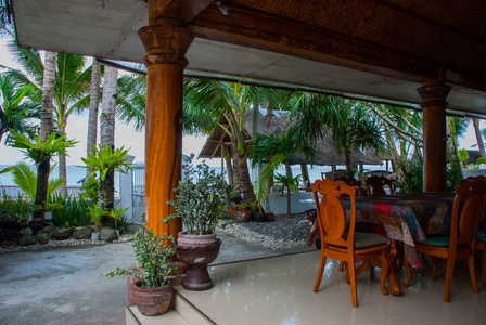 与木桌和椅子上的棕榈树和海背景酒店。香兰，班乃菲律宾