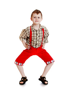 有趣的小男孩，穿红色短裤与吊带