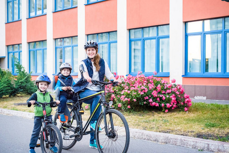 骑自行车上班，母亲与快乐的孩子骑自行车在户外的家庭