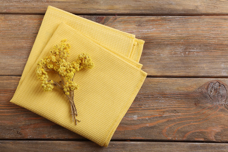 美丽的干燥花在餐巾纸上木制的背景上