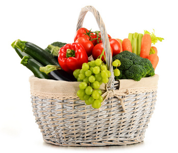 有机蔬菜和水果在柳条篮子上白色孤立