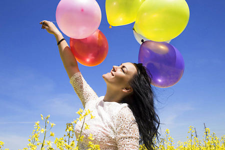 年轻漂亮的女人，拿着彩色的气球享受与新鲜