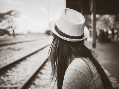 黑色和白色的旅行者女人等铁路站台的火车开