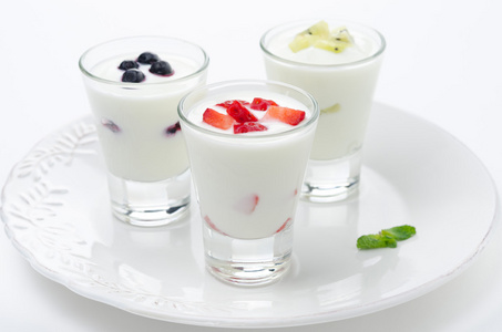 三种酸奶水果在水平的玻璃烧杯