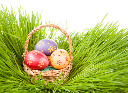 复活节的概念。 放在篮子里的鸡蛋放在草地上