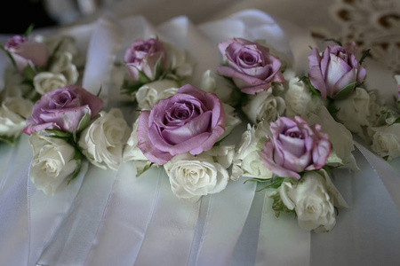 花安排与薄的纸紫色玫瑰, 婚礼配件, 新娘细节, 放置在白色的布上