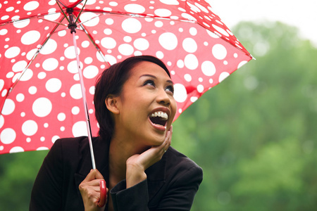 在伞下避雨的年轻女子