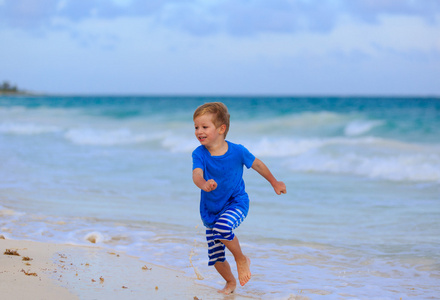 快乐的小男孩在沙滩上运行