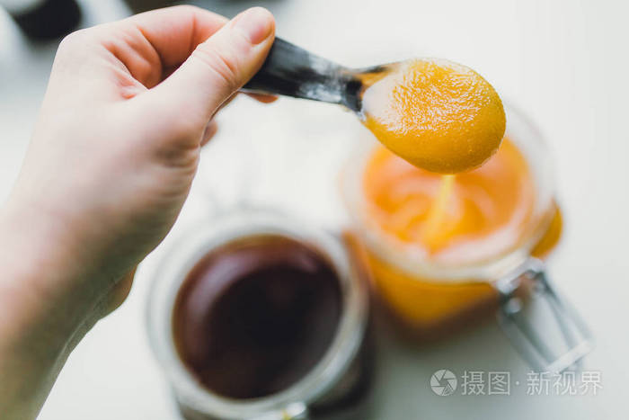 手拿着勺子用甜甜的蜂蜜