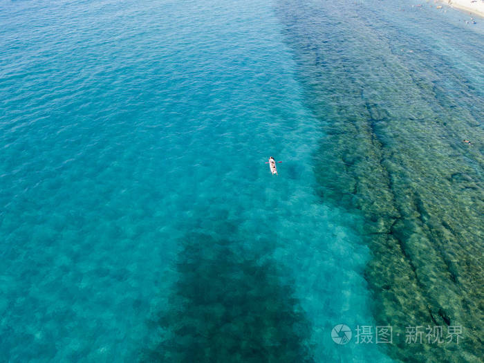 独木舟上透明的海上漂浮的水的鸟瞰图.泳客在海上.
