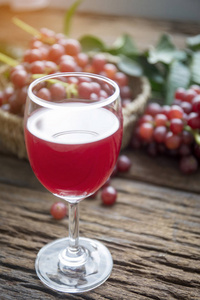 杯酒或葡萄汁和木制的桌子上的水果
