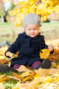 秋天的可爱小女孩叶子在美丽公园