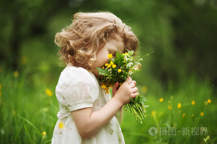 小女孩闻着一束鲜花