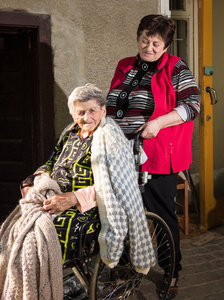 老妇人坐在轮椅上和她的女儿