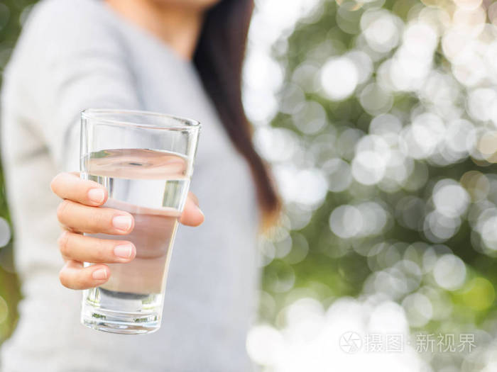 特写的女人手拿着一杯水