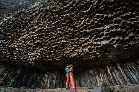 年轻的夫妇在背景上的岩石