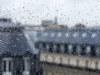 巴黎，法国，2015 年 8 月 27 日。从对城市的阴雨天气窗口视图。巴黎的雨淋湿，在玻璃上的一滴雨的屋顶