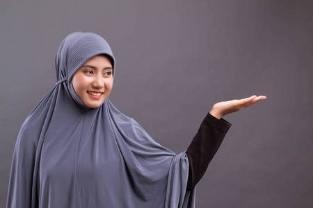 穆斯林妇女指向手到空白空间