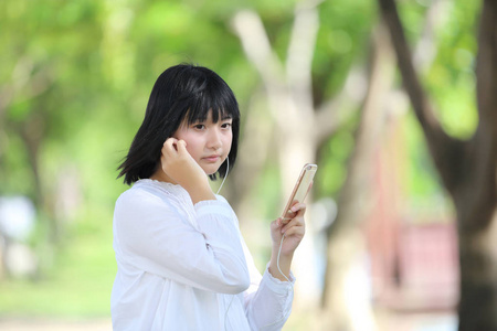 关于智能手机肖像与 g 亚洲年轻女人听音乐