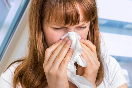 生病的妇人有流感和打喷嚏到手帕