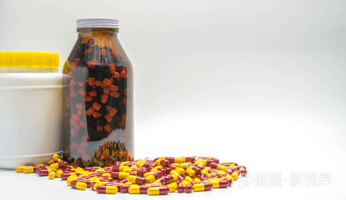 在白色背景上孤立的琥珀色棕色瓶抗生素药物丸