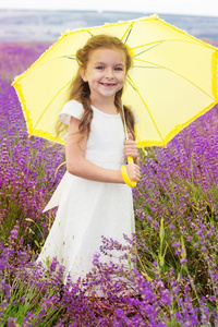 快乐的小公主，在把黄色的雨伞薰衣草田