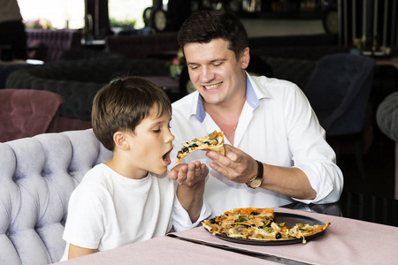 父亲儿子吃意大利的比萨饼
