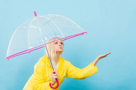 女人穿着雨衣打着伞检查天气