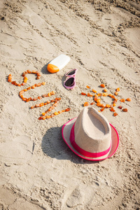 词和形状的太阳 太阳镜 防晒霜和草帽在海滩