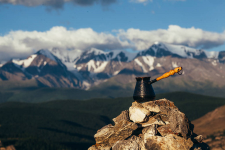 喝咖啡与令人惊叹的山景。美丽的喜马拉雅山景观与咖啡杯和 cezve。外喝着咖啡的雪域景观背景上