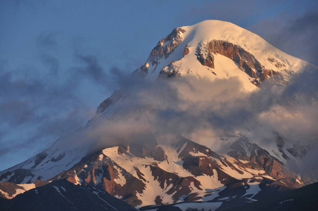 白雪皑皑的山脉卡兹别克山麓在黎明和在哪里山谷是教会娃娃三位一体。格鲁吉亚