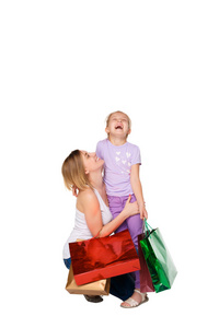 快乐的一对母女，手里拿着购物袋站在Studi