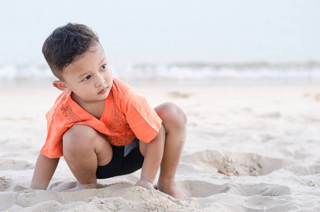 男孩，大约在 45 岁，白色的沙子在沙滩上玩单独在一起