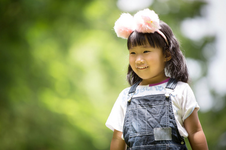 在公园绿色背景下的亚洲女孩的肖像