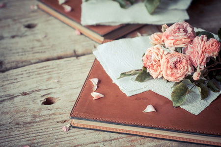 粉红玫瑰用记事本木制的桌子上