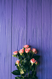 在木桌子上紫色的粉红玫瑰花束。顶视图与副本空间