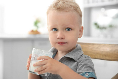 可爱的小男孩拿着杯牛奶
