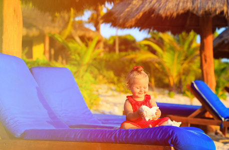 可爱的小宝贝女孩与热带海滩上的贝壳