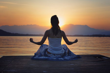 女人冥想在金色的夕阳