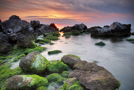 多姿多彩的夏天海景。在日落时的岩石海岸