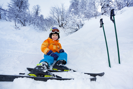雪磨损滑雪装小滑雪男孩休息