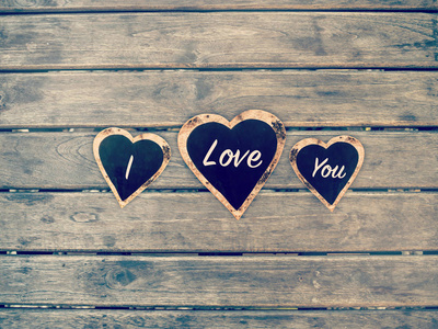 我爱你的心形状上黑板和木板墙上