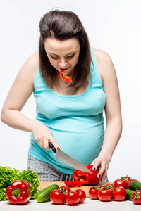 孕妇准备在厨房里的蔬菜沙拉
