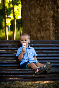 夏季的一天在公园里吃冰淇淋的小男孩