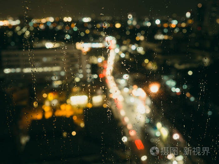 晚上从窗户下雨的城市景观