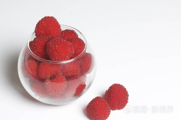 大红色莓果是类似于玻璃花瓶中的覆盆子.在白色的背景
