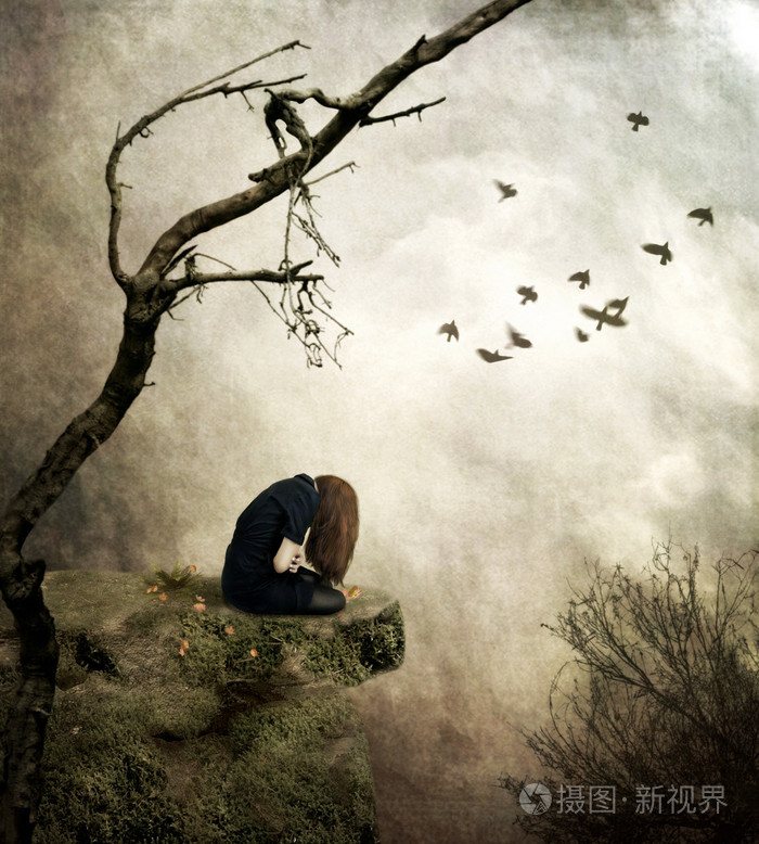 孤单的小女孩坐在一块岩石在悲伤中