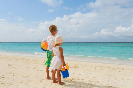 小男孩和女孩走在沙滩上玩