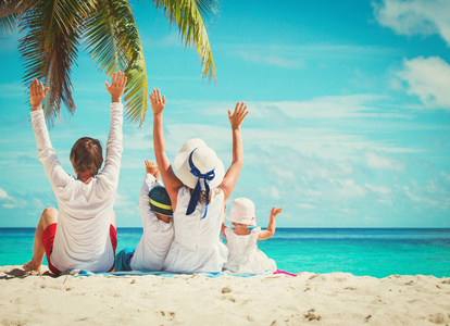 幸福的家庭，有两个孩子在沙滩上举起手来