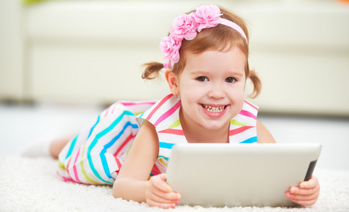 快乐的孩子玩在平板电脑中的小女孩